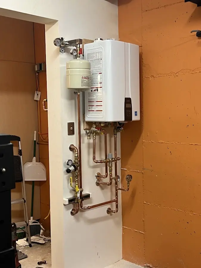 Plumbing technician inspecting water heater connections in Edinburg
